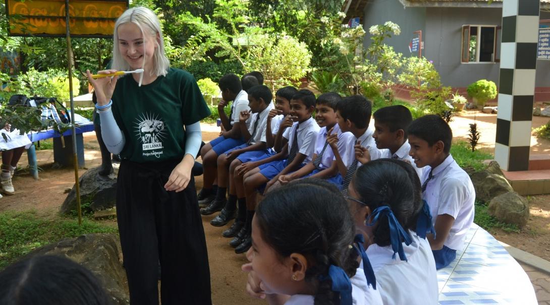 A female intern teaches a group of children how to correctly brush their teeth whilst on her public health internship in Sri Lanka with Projects Abroad. Female Projects Abroad intern can be seen teaching a group of children how to correctly brush their teeth whilst on her public health internship in Sri Lanka.